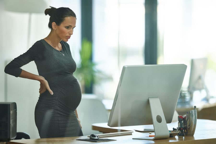 pregnant woman stand up desk working home office